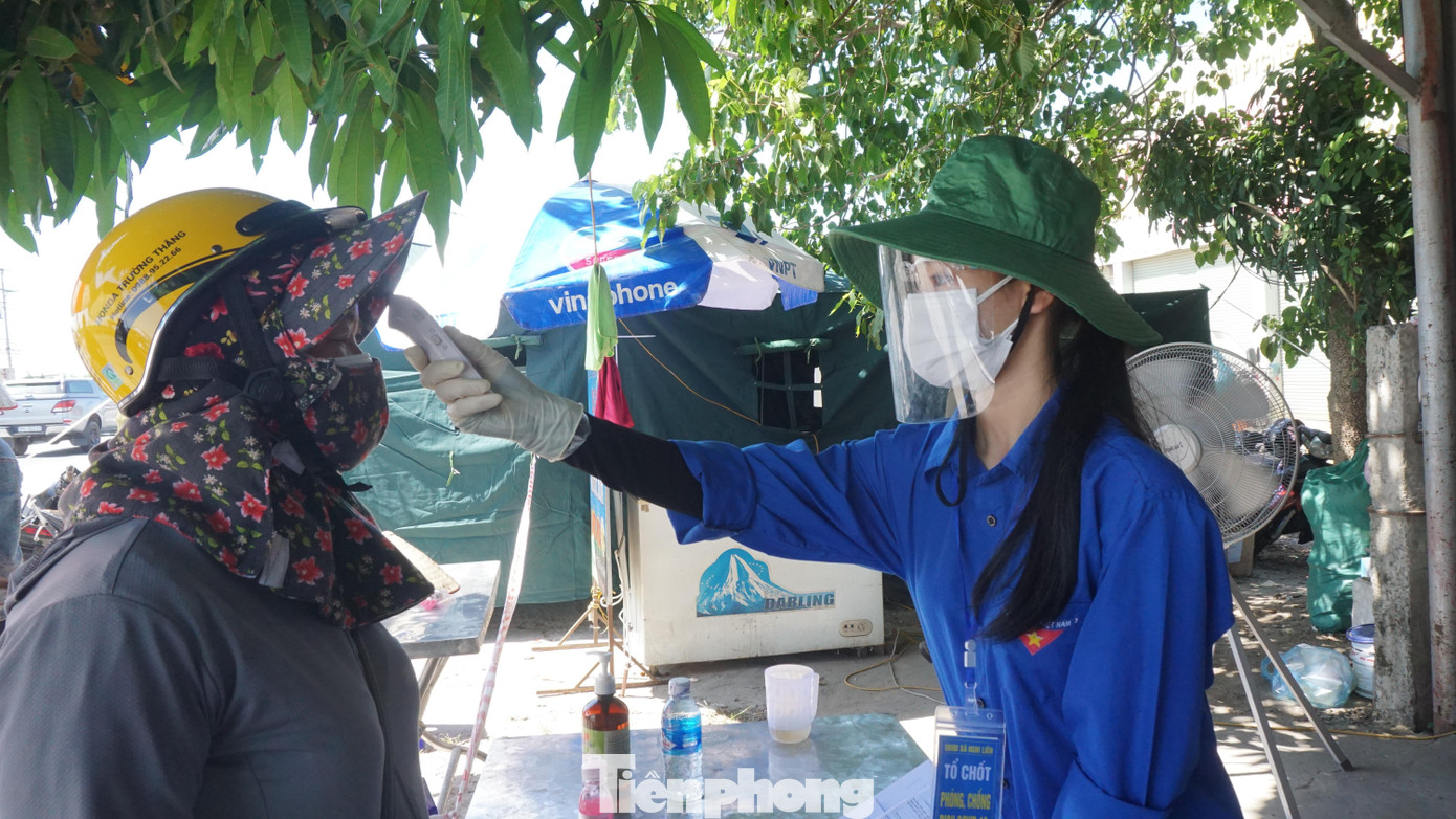 Lê Thị Bảo Trâm kiểm tra thân nhiệt cho người đi đường tại chốt kiểm soát