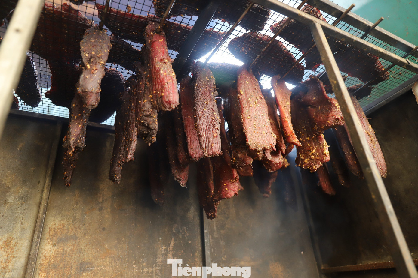 Từng miếng thịt được xâu vào que tre, treo lên trên bếp củi.