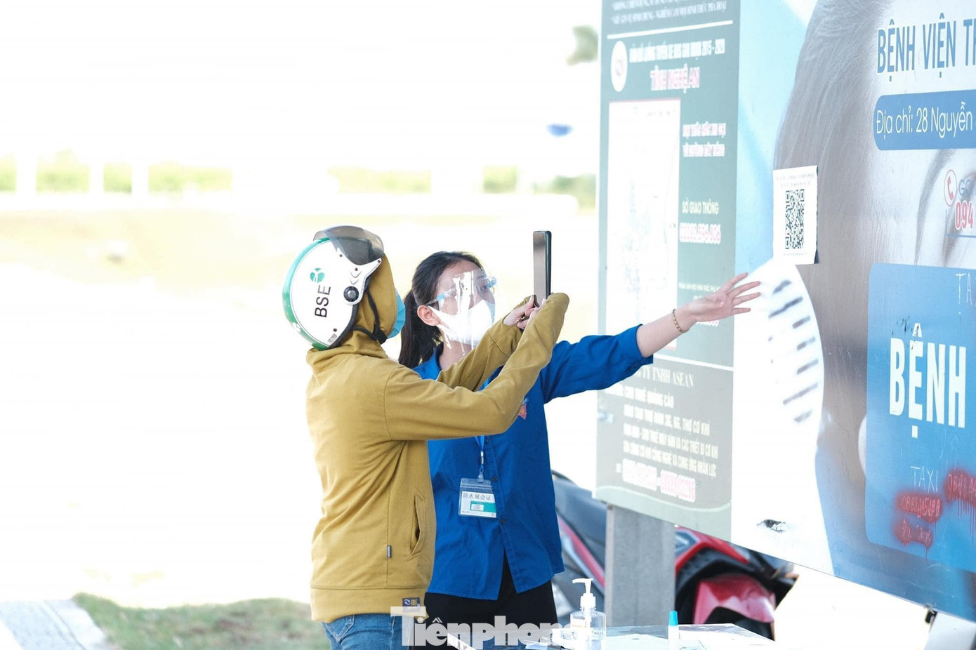 Một nữ sinh hướng dẫn người dân khai báo y tế qua app điện thoại