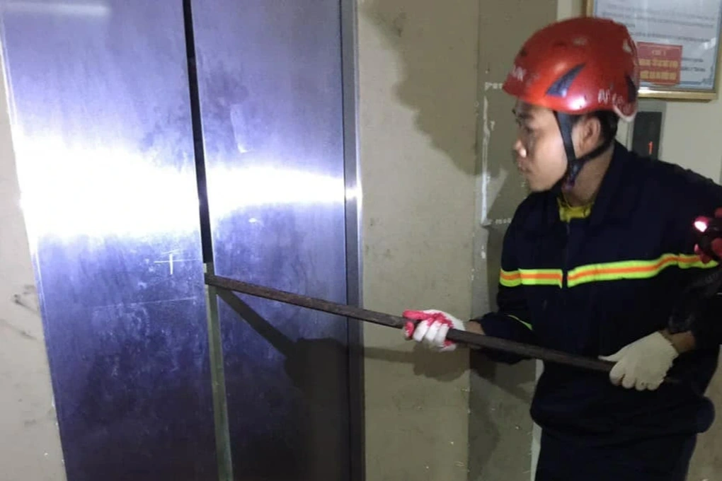 Cảnh sát Phòng cháy chữa cháy dùng xà beng để cạy thang máy, giải cứu người dân mắc kẹt