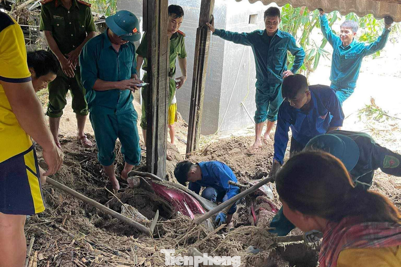 Chiếc xe máy bị &quot;mắc kẹt&quot; dưới bùn đất. Người dân, lực lượng công an, dân quân, đoàn thanh niên chung sức đưa chiếc xe lên.