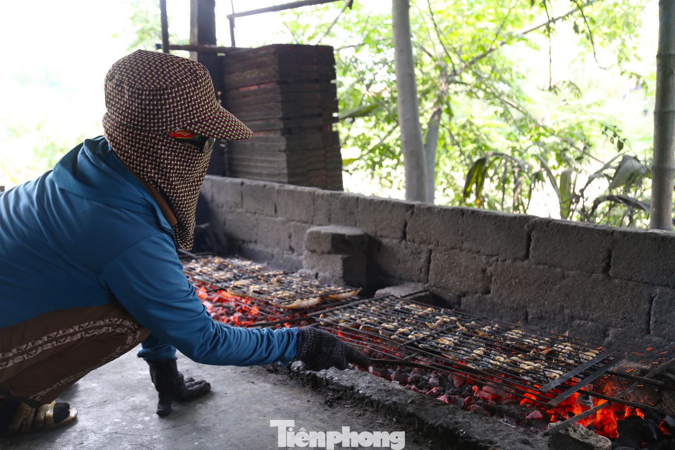 11 giờ trưa, khi nhiệt độ lên tới gần 40 độ C, khuôn mặt bà Hoàng Thị Hoa (53 tuổi, trú xóm Xuân Bắc, xã Diễn Vạn) đỏ rần rần. Nhễ nhại mồ hôi, bà vẫn kiên trì ngồi bên bếp than đỏ rực, tay liên tục lật, nướng cá. “Nghề này mùa hè là cực nhất, trời quá nóng, ra mồ hôi nhiều nên dễ mất sức. Để giữ được mức lửa vừa phải, cá chín đến độ, người nướng phải có kinh nghiệm, lật trở càng đều tay, cá càng thơm ngon”, bà Hoa chia sẻ.