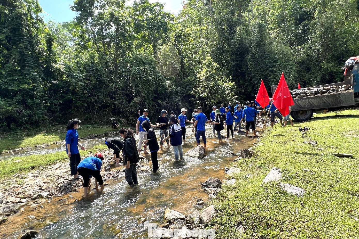 Đoàn viên thanh niên phải chuyền tay nhau những hòn đá để xây dựng điểm tập bơi.