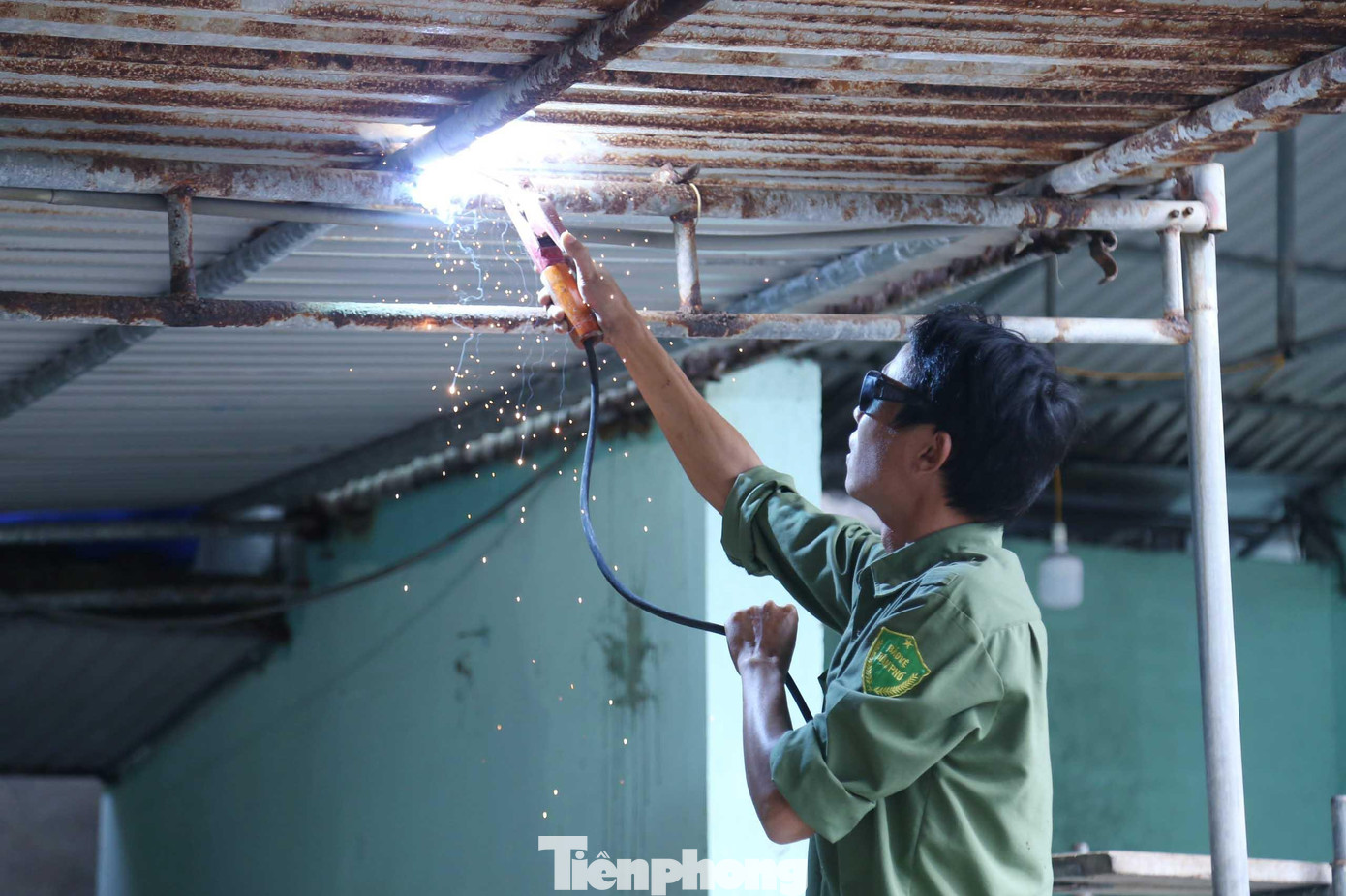 Dùng máy hàn cắt chốt thép, tháo dỡ các mảng tôn chắn.