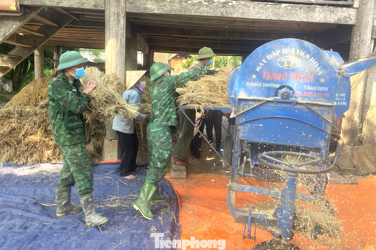 Giúp dân tuốt lúa tại nhà.