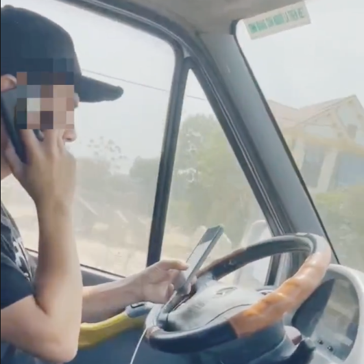 Hình ảnh tài xế vừa nghe điện thoại vừa nhắn tin khi đang lái xe. Ảnh cắt từ clip