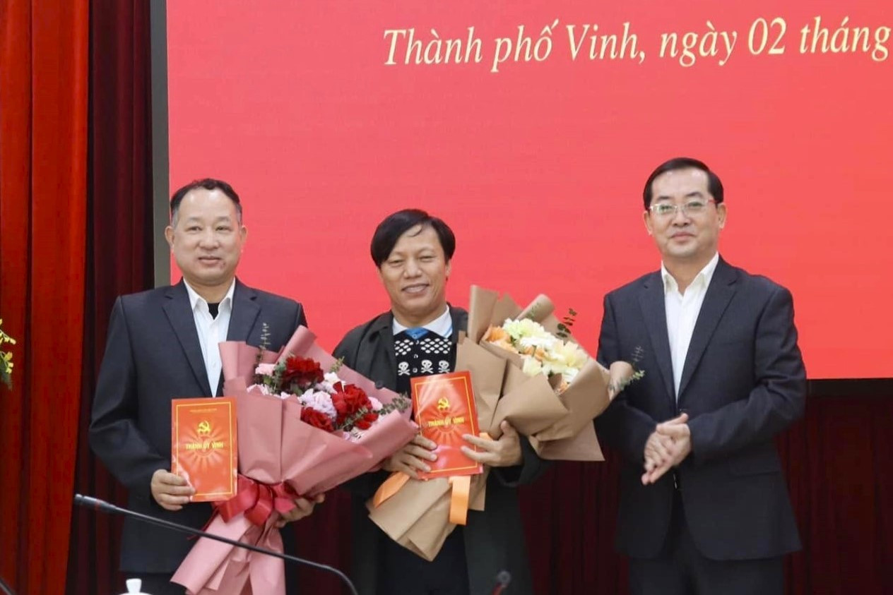 Phó Bí thư Thành ủy Vinh Nguyễn Văn Lư (bên phải) trao quyết định nghỉ hưu cho các cán bộ thuộc cơ quan, đơn vị của thành phố.