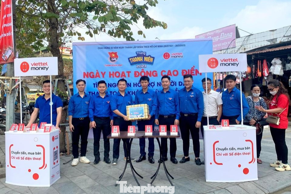 Cấp tỉnh, thăm, tặng quà các đội hình tình nguyện, tổ hỗ trợ chuyển đổi số cộng đồng tại chợ Quán Lau, bộ phận một cửa Công an tỉnh, chợ Hưng Dũng, Trung tâm Phục vụ hành chính công tỉnh, chợ Quán Hành, Bộ phận một cửa Công an huyện Nghi Lộc. Trong ảnh, anh Vũ Minh Thảo – Uỷ viên BCH, Phó Ban Thanh niên Nông thôn Trung ương Đoàn cùng Ban Thường vụ Tỉnh Đoàn Nghệ An tặng quà cho đội thanh niên tình nguyện tham gia hỗ trợ người dân đăng ký tài khoản và thanh toán trực tuyến qua ví điện tử Viettel Money tại chợ Quán Lau, Thành phố Vinh.