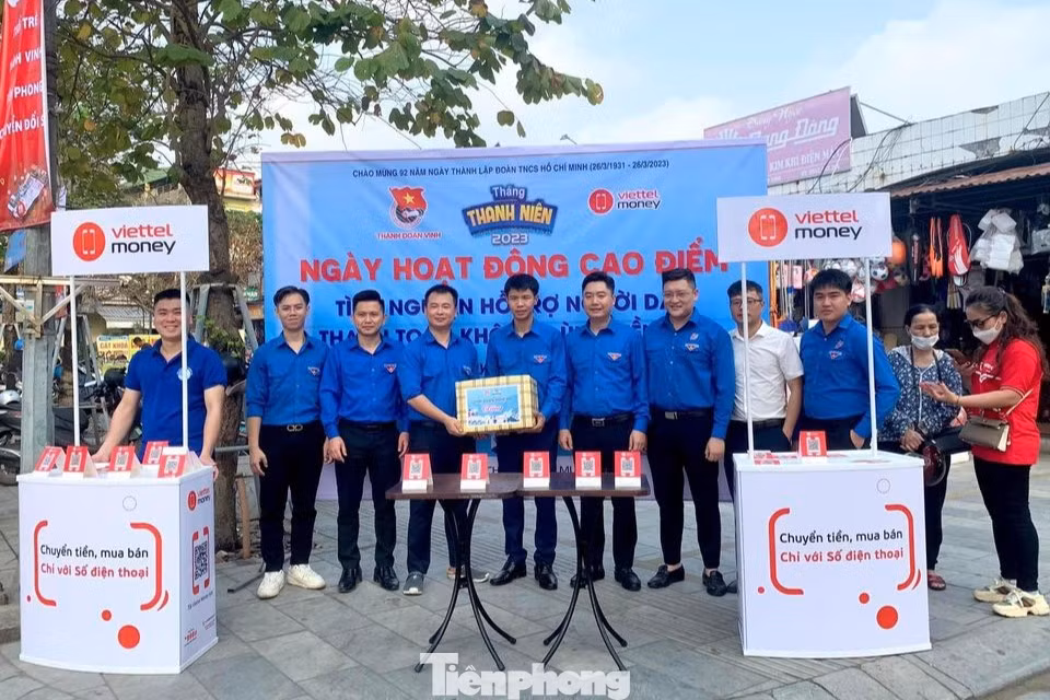 Cấp tỉnh, thăm, tặng quà các đội hình tình nguyện, tổ hỗ trợ chuyển đổi số cộng đồng tại chợ Quán Lau, bộ phận một cửa Công an tỉnh, chợ Hưng Dũng, Trung tâm Phục vụ hành chính công tỉnh, chợ Quán Hành, Bộ phận một cửa Công an huyện Nghi Lộc. Trong ảnh, anh Vũ Minh Thảo – Uỷ viên BCH, Phó Ban Thanh niên Nông thôn Trung ương Đoàn cùng Ban Thường vụ Tỉnh Đoàn Nghệ An tặng quà cho đội thanh niên tình nguyện tham gia hỗ trợ người dân đăng ký tài khoản và thanh toán trực tuyến qua ví điện tử Viettel Money tại chợ Quán Lau, Thành phố Vinh.
