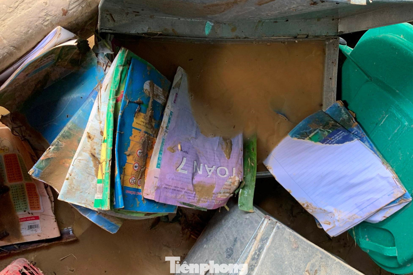 Sách vở, dụng cụ học tập, sinh hoạt của học sinh, đồ dùng giảng dạy của giáo viên bị ướt sũng, nằm rải rác giữa bùn đất.