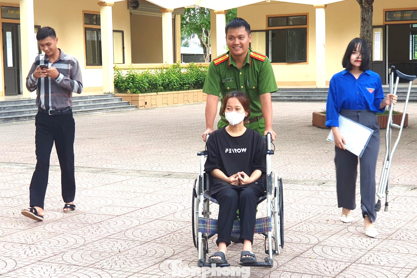 Thí sinh vừa mổ ruột thừa, được cán bộ Công an huyện Thanh Chương hỗ trợ đẩy xe lăn ra vào điểm thi.