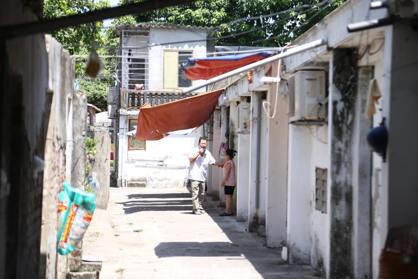 Men theo con ngõ nhỏ dẫn vào "xóm chạy thận" trên đường Lê Ninh (TP. Vinh, tỉnh Nghệ An), không khí oi bức, bí bách, nóng hầm hập. Trong dãy phòng trọ chật hẹp này có 16 bệnh nhân suy thận đang thuê ở.