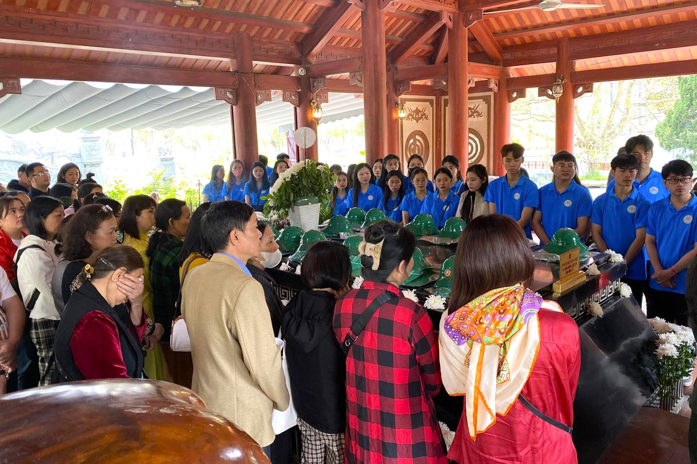 Bên ngôi mộ chung, du khách lắng lòng nghe thuyết minh viên kể lại giây phút hy sinh đầy xúc động của 13 liệt sĩ thanh niên xung phong.