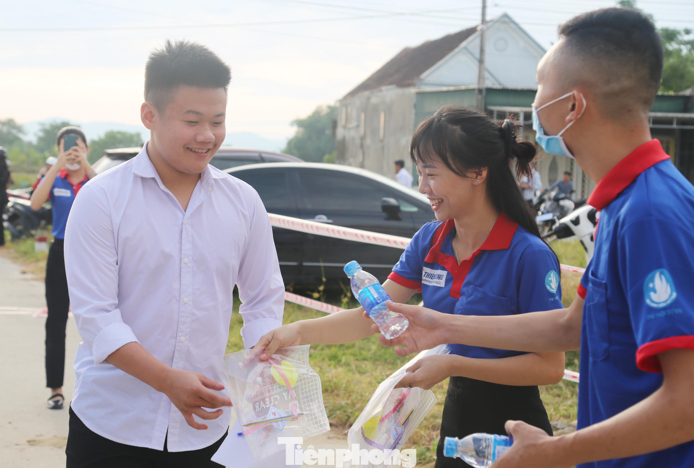 Thanh niên tình nguyện phát túi đựng đề thi, bút chì và nước cho thí sinh.