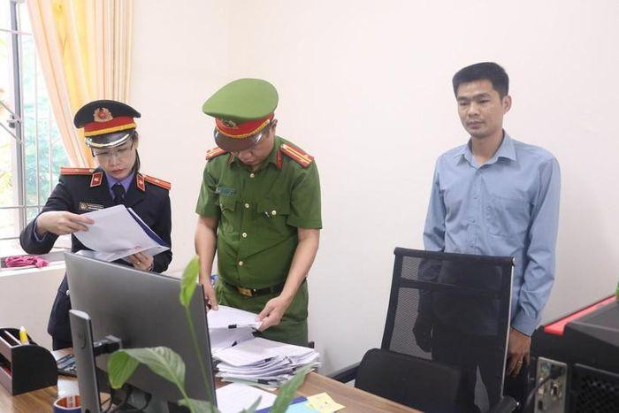 Lực lượng chức năng khám xét nơi làm việc của Phạm Văn Tài (bên phải).