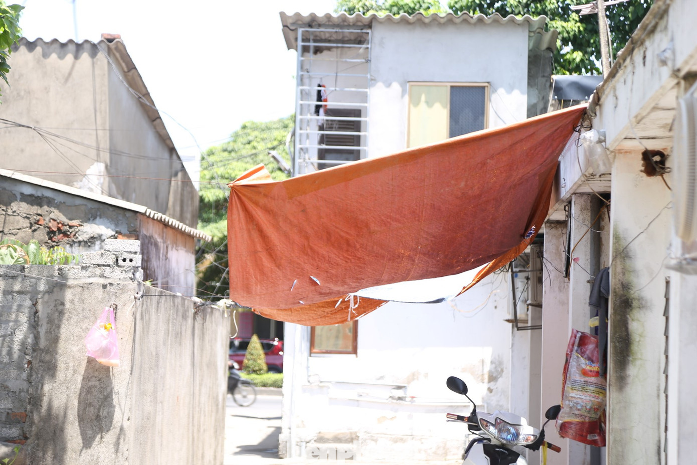 Nắng nóng, cư dân "xóm chạy thận" phải lấy bạt che chắn phía trước căn phòng trọ chật hẹp. Những tấm bạt cũng đã rách nát từ bao giờ.