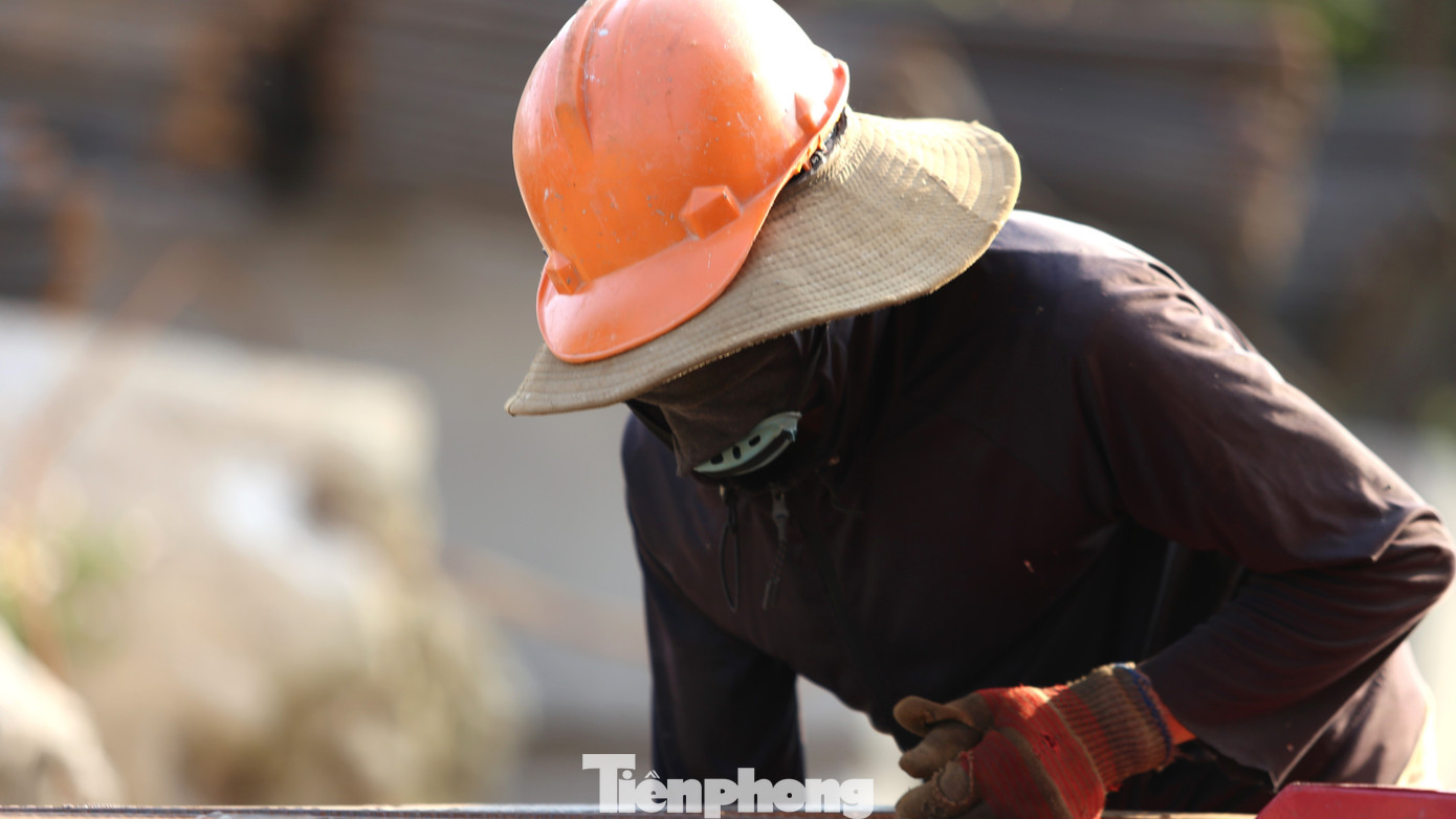 Để tránh nắng, công nhân phải bịt kín người bằng nhiều lớp áo, mũ, khẩu trang,...