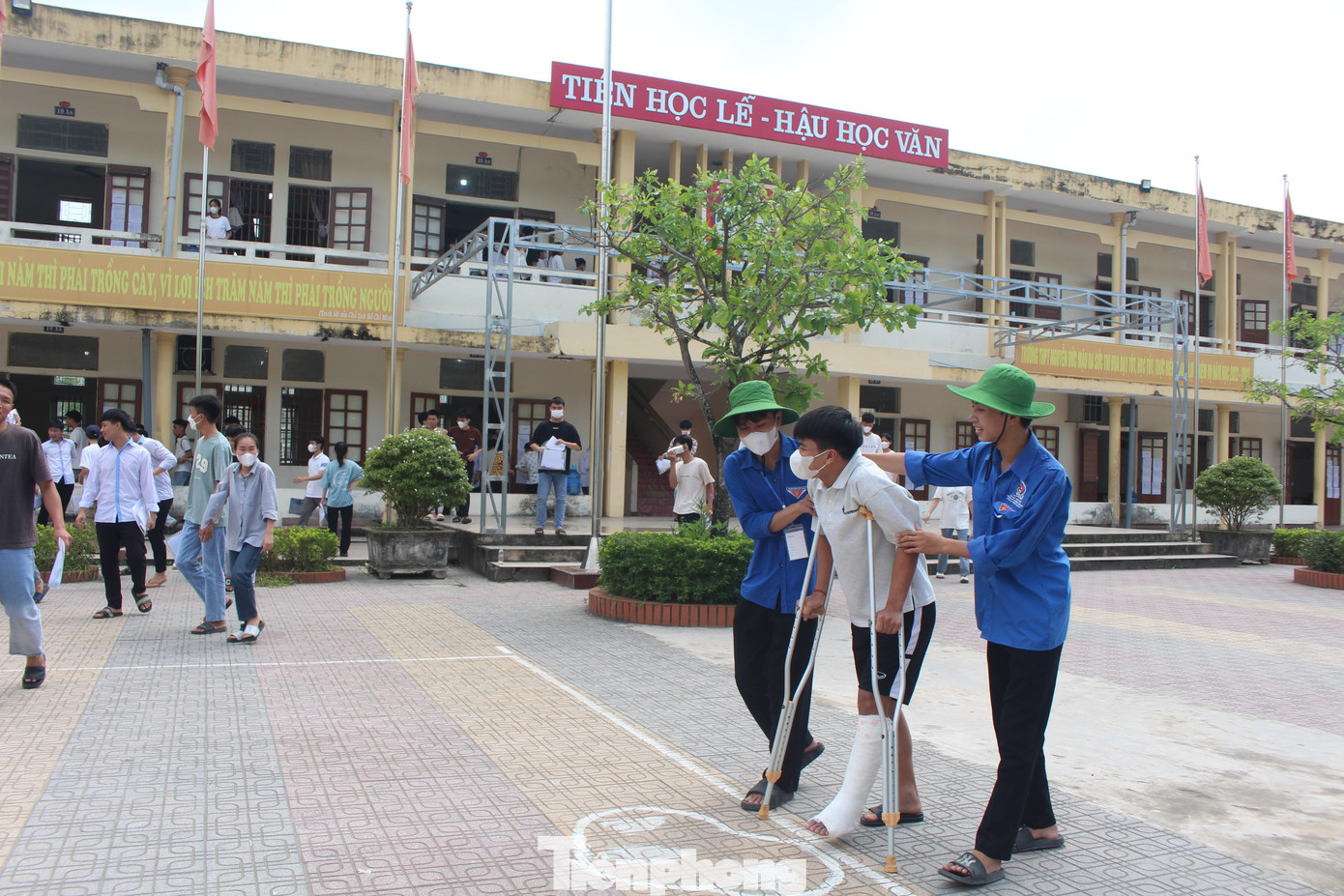 Thí sinh Lê Văn Dương chống nạng được đoàn viên hỗ trợ đưa vào phòng thi