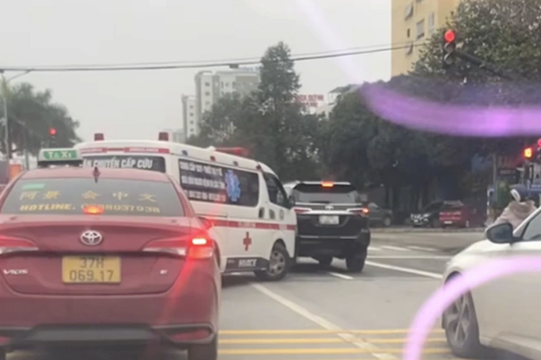 Xe ô tô màu đen dừng đèn đỏ không nhường đường cho xe cấp cứu. Ảnh: Cắt từ video