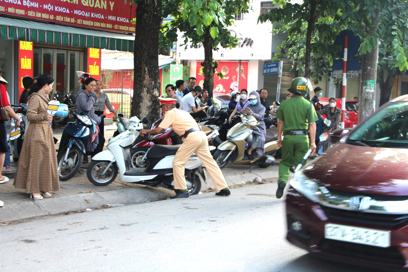 Hỗ trợ dắt, đẩy xe cho phụ huynh thí sinh.