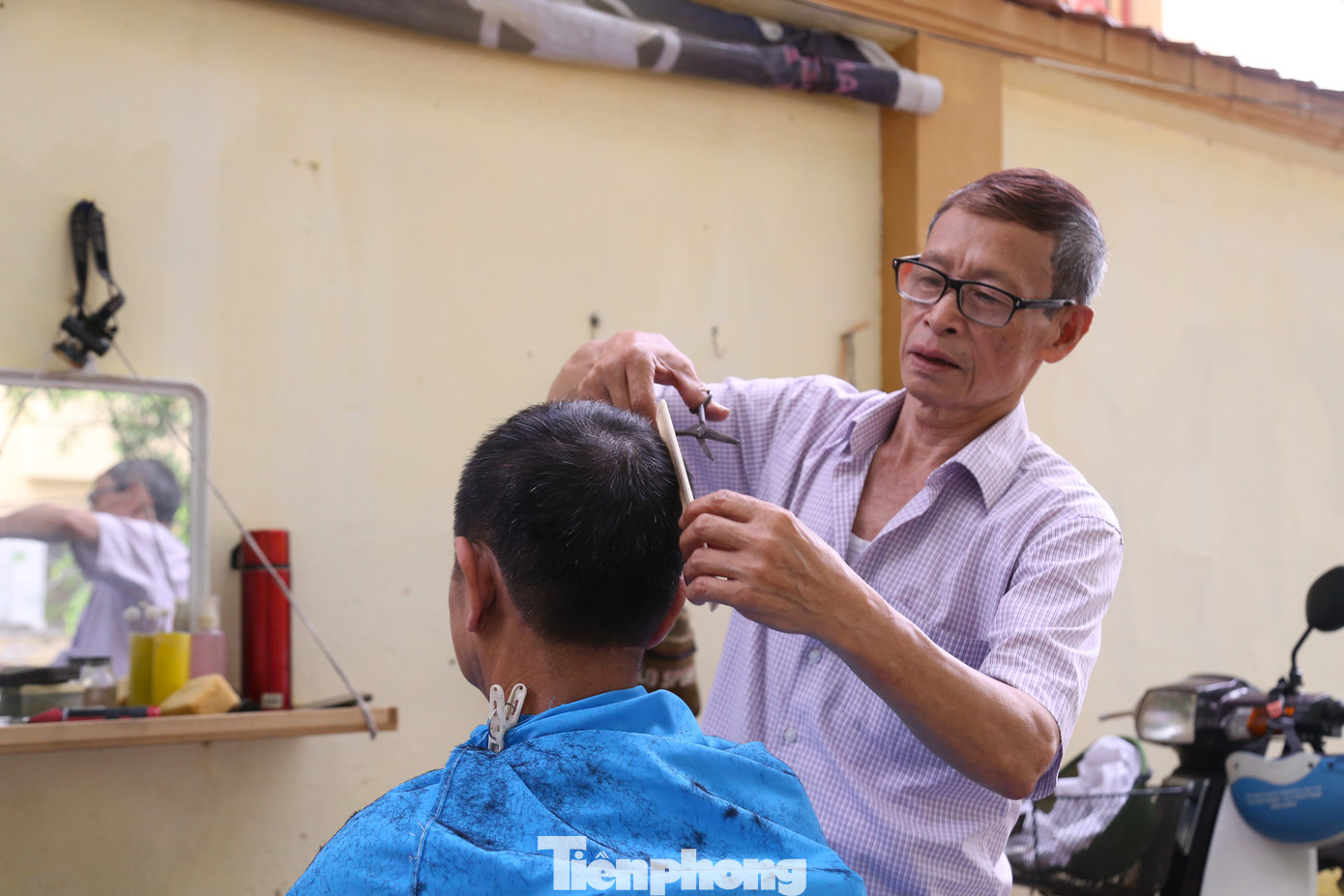 Một 'tiệm' cắt tóc vỉa hè ở phường Hưng Phúc, thành phố Vinh vẫn mở cửa đón khách sáng 1/5.