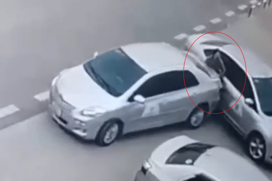 Người phụ nữ bị kẹt giữa 2 xe, tỏ ra vô cùng đau đớn