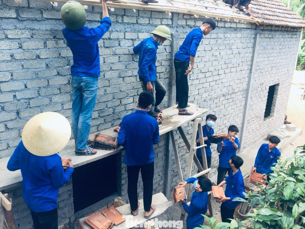 Dù nắng nóng, áo xanh tình nguyện vẫn tích cực tham gia. Mỗi người một việc, người vận chuyển ngói, người lợp,…