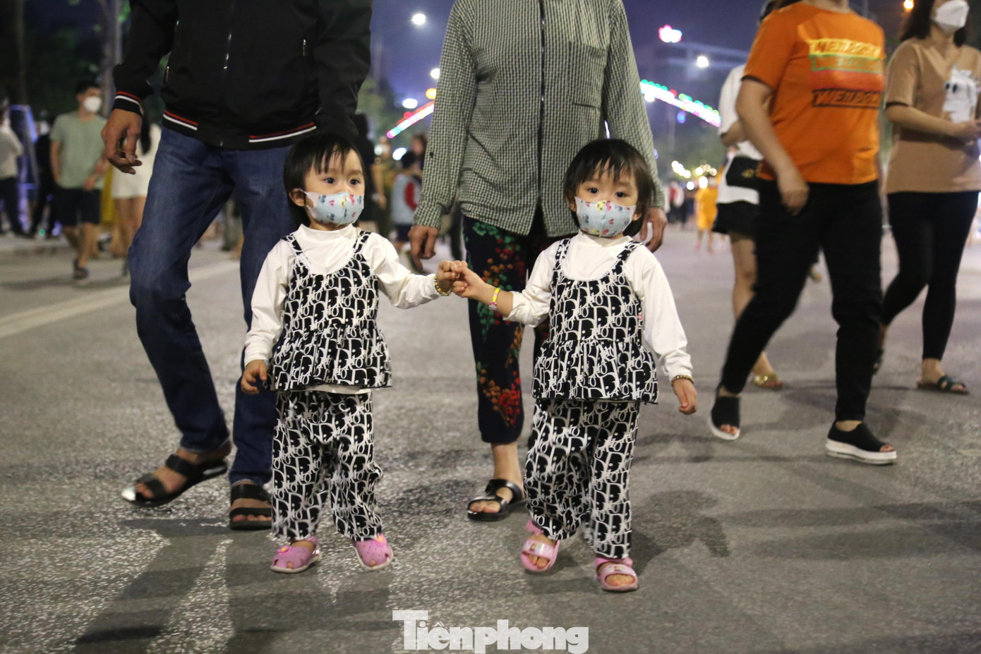 Hai bé sinh đôi được bố mẹ cho đi chơi ở phố đi bộ
