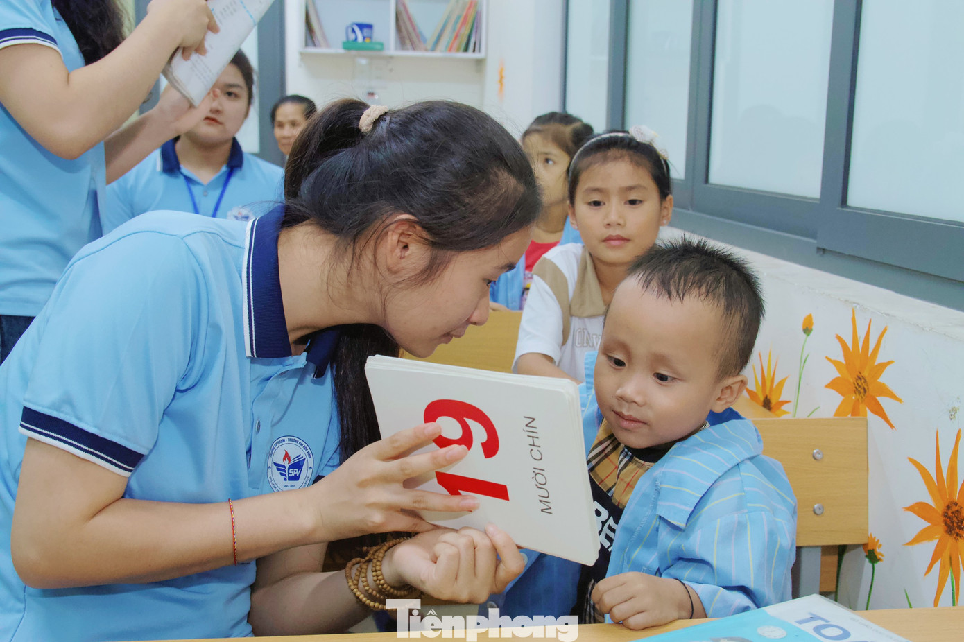 Tỉ mỉ chỉ cho một bé trai tập viết, bạn Lương Thị Nhược Hằng (SN 2003, lớp 62A4 Giáo dục tiểu học, Trường Đại học Vinh) cho biết, thành viên của lớp học không cố định, có khoảng gần 20 em với độ tuổi dao động từ khoảng 4 -10 tuổi và không cố định vì nhiều lý do.