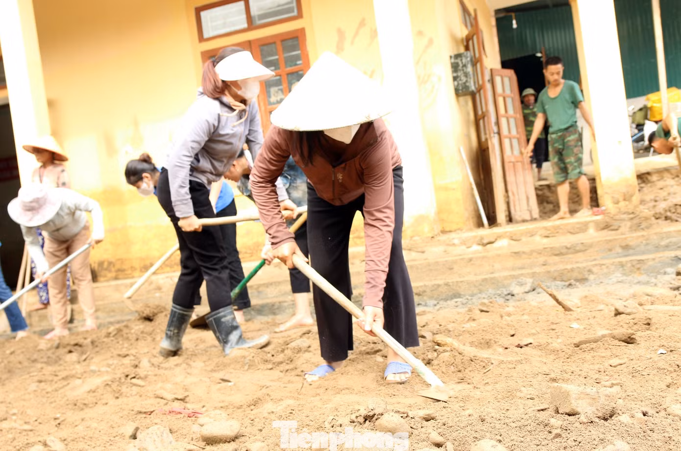 Người dân địa phương cũng được huy động tham gia dọn bùn đất.
