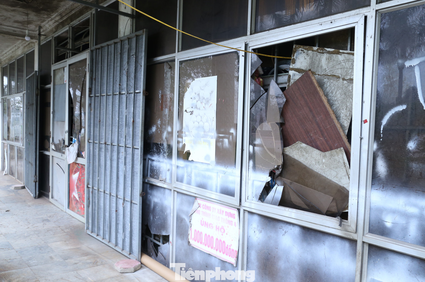 Những tấm kính đã vỡ tung tóe được chắp vá bằng tấm bìa cát tông