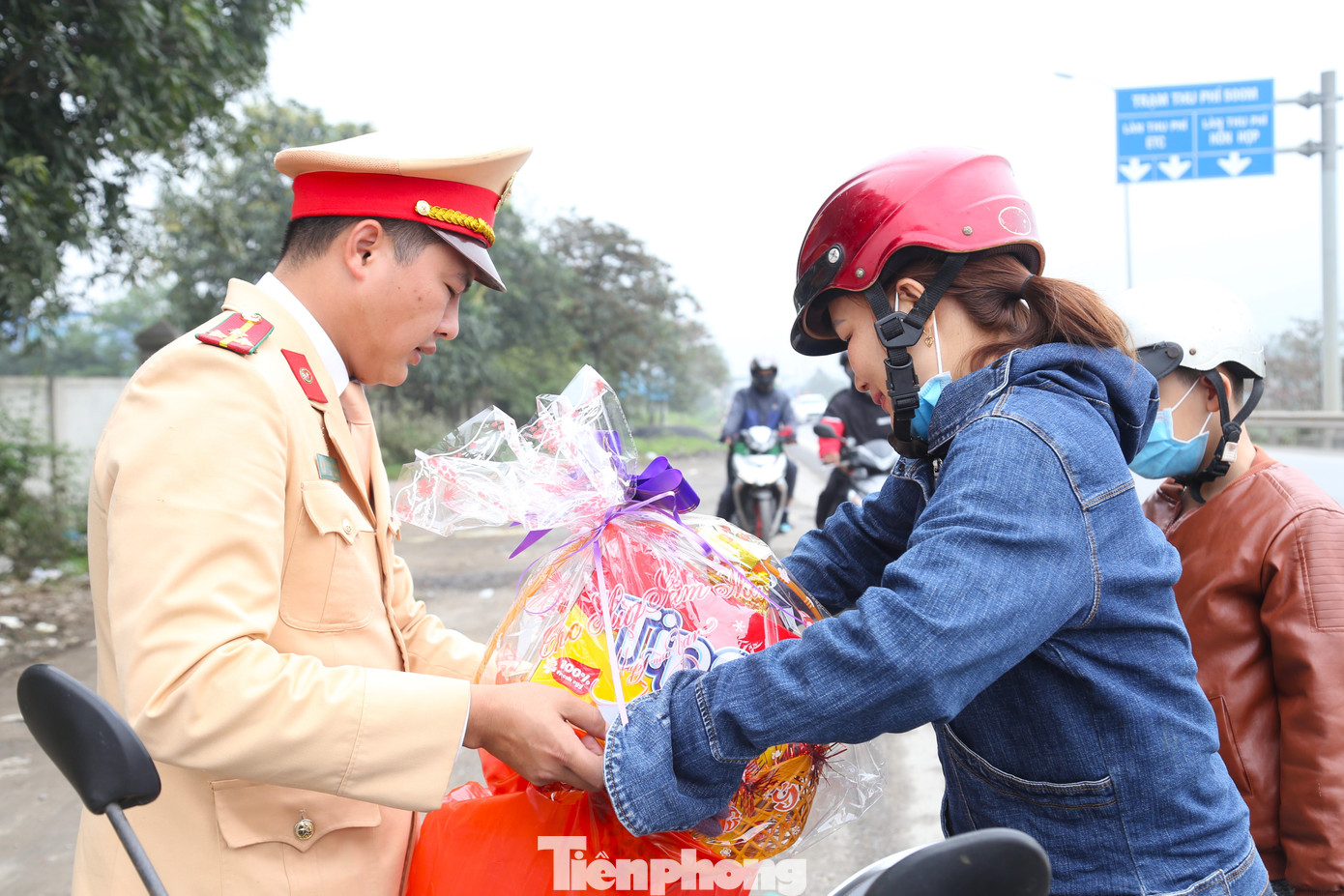 Cùng chồng và hai con nhỏ chạy xe máy từ tỉnh Quảng Bình về quê ở huyện Quỳnh Lưu (Nghệ An) ăn Tết, chị Hoàng Thị Vân xúc động khi được nhận món quà của lực lượng CSGT Nghệ An.