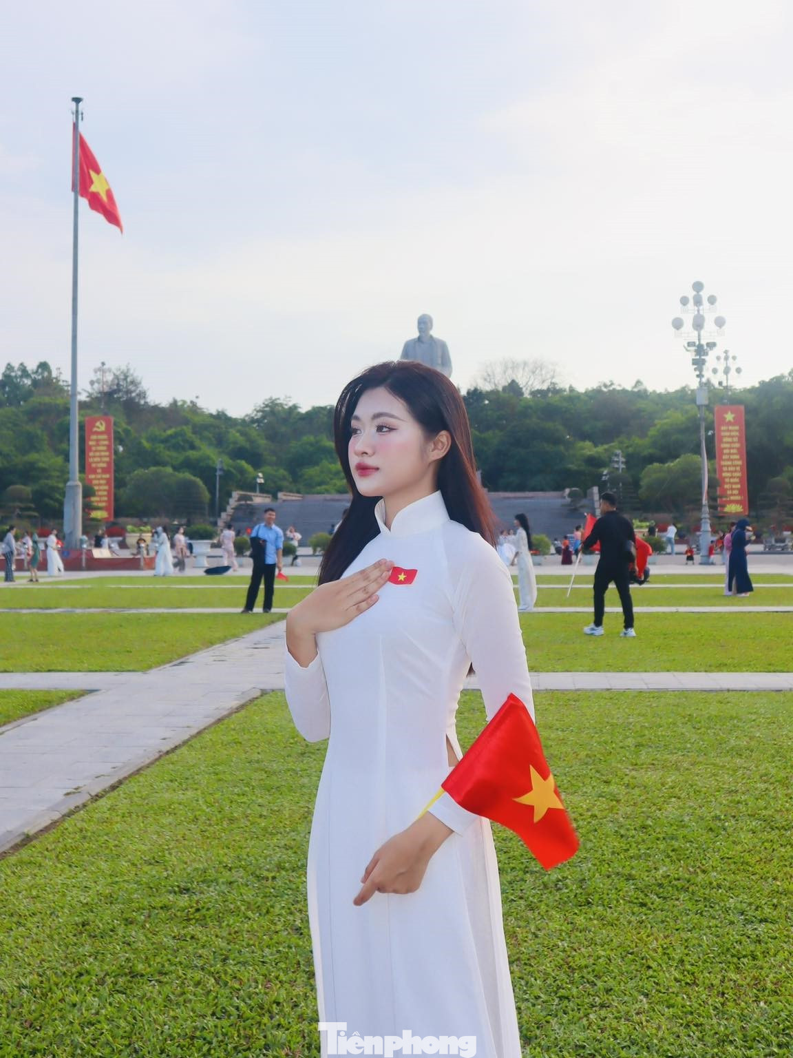 Các bạn trẻ trong tà áo dài nền nã, tay cầm lá cờ Tổ quốc, cùng nhau lưu giữ khoảnh khắc kỷ niệm.