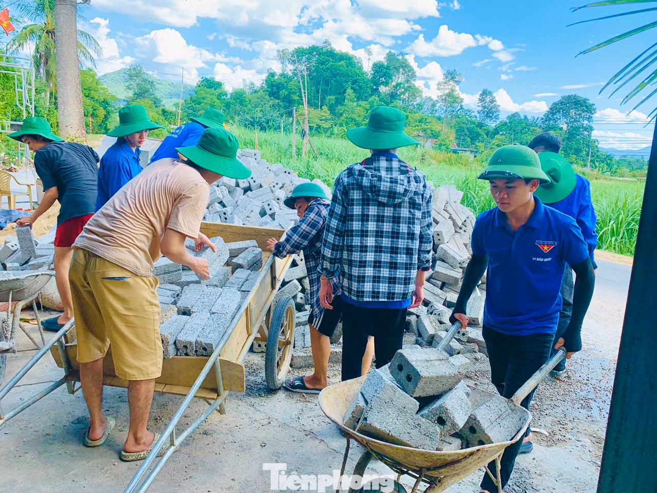 Vi Bảo Quốc (ngoài cùng bên phải) hỗ trợ vận chuyển gạch