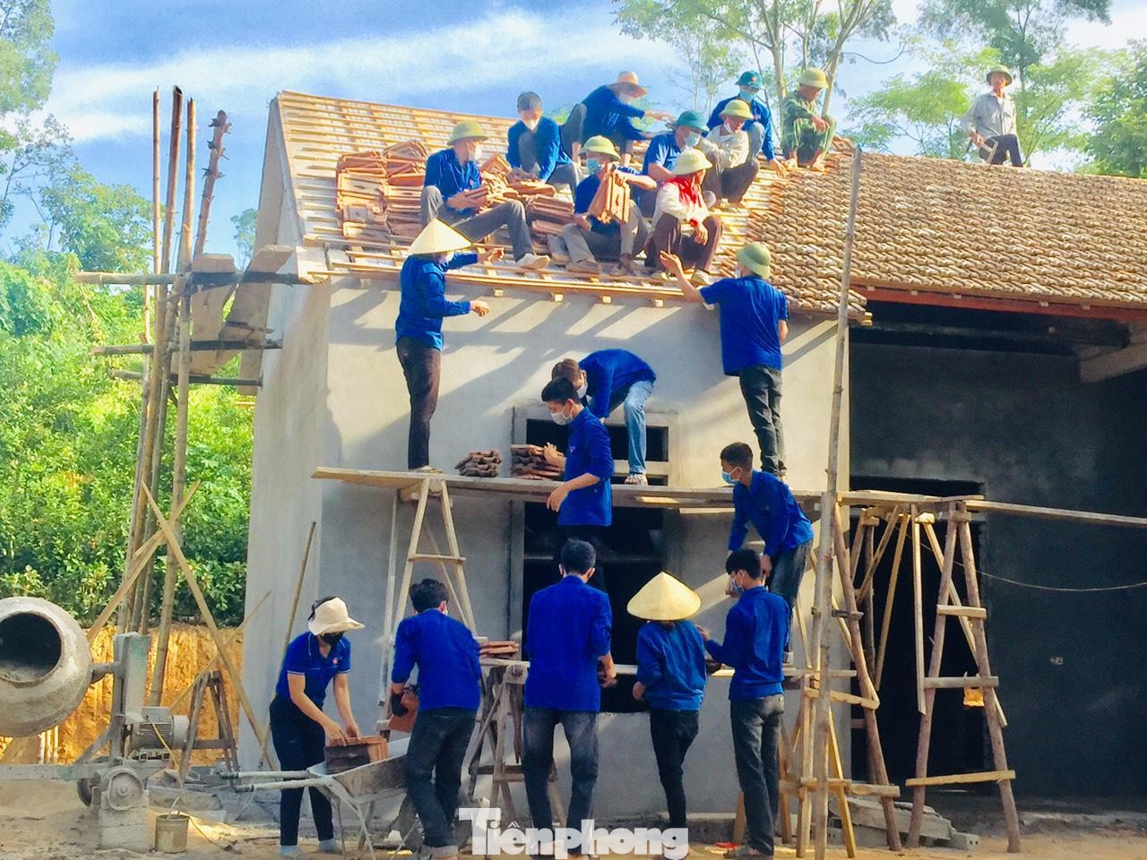 Dưới cái nắng gắt, các bạn trẻ vẫn tích cực di chuyển từng viên ngói để lợp lại mái nhà cho ông Đại.