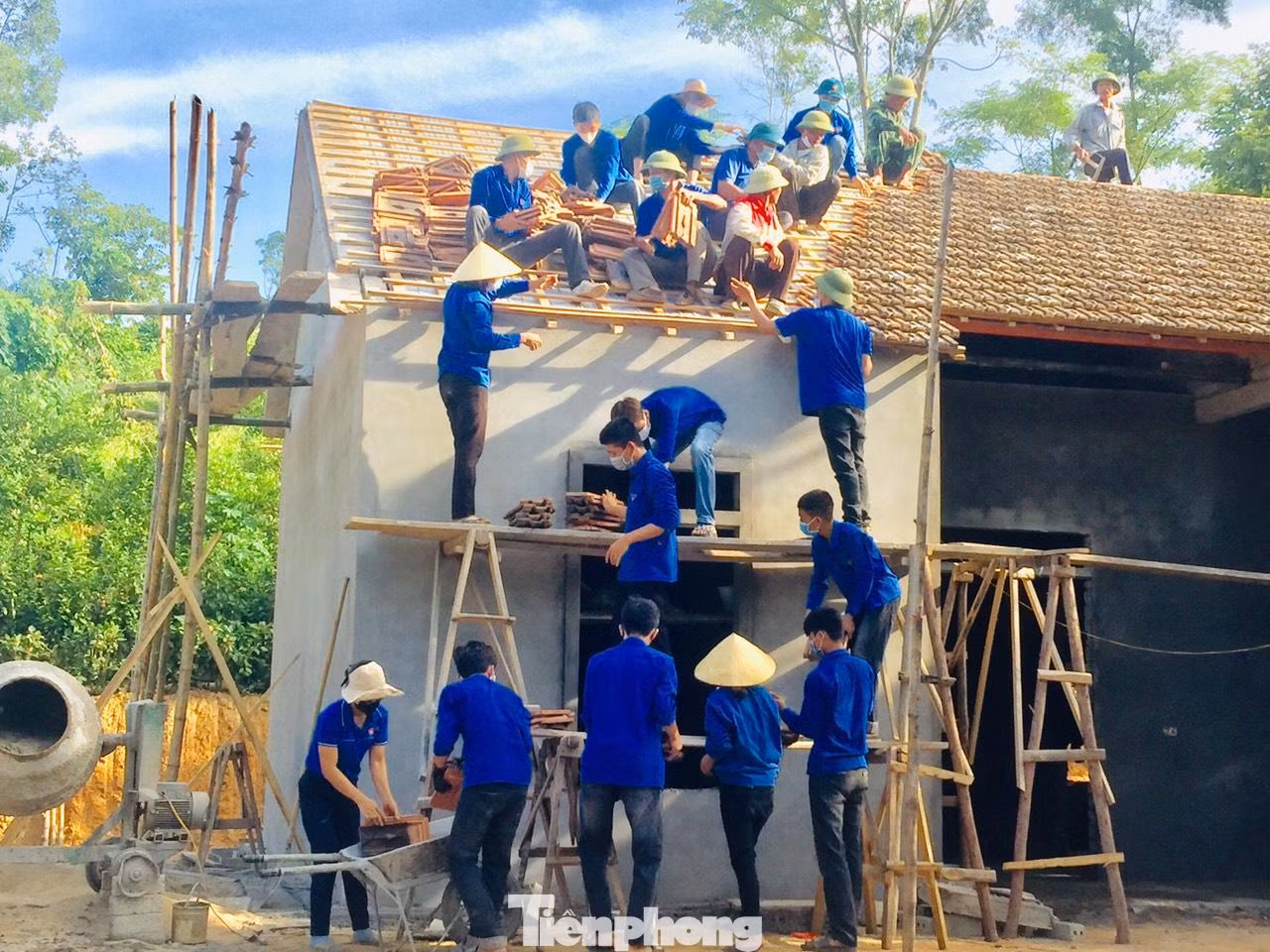 Dưới cái nắng gắt, các bạn trẻ vẫn tích cực di chuyển từng viên ngói để lợp lại mái nhà cho ông Đại.