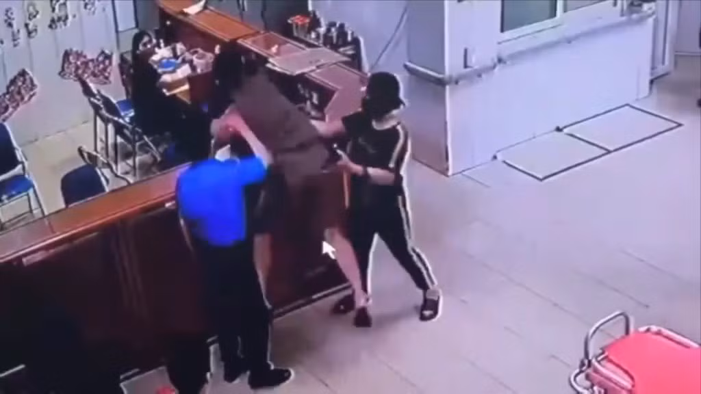 Hình ảnh Tuấn Anh chồm qua quầy tát vào mặt nữ điều dưỡng.