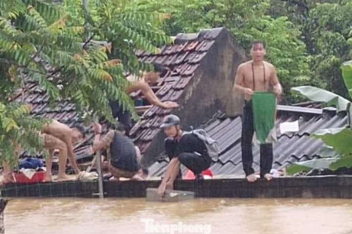 Các em học sinh đội mưa chờ lực lượng chức năng ứng cứu.