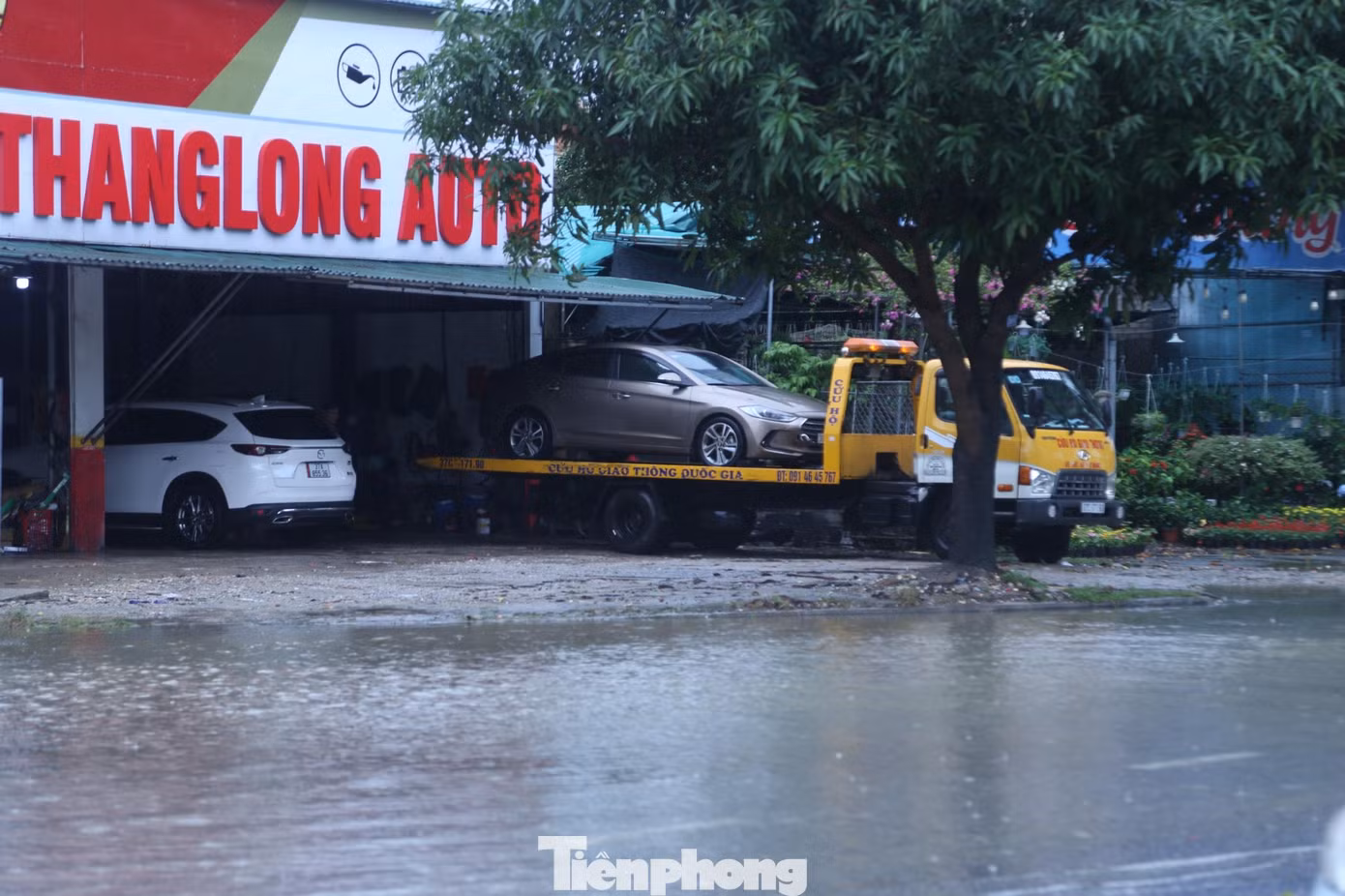 Những ô tô chết máy khi lưu thông qua những đoạn đường ngập sâu được đưa tới gara sửa chữa Những ô tô chết máy khi lưu thông qua những đoạn đường ngập sâu được đưa tới gara sửa chữa
