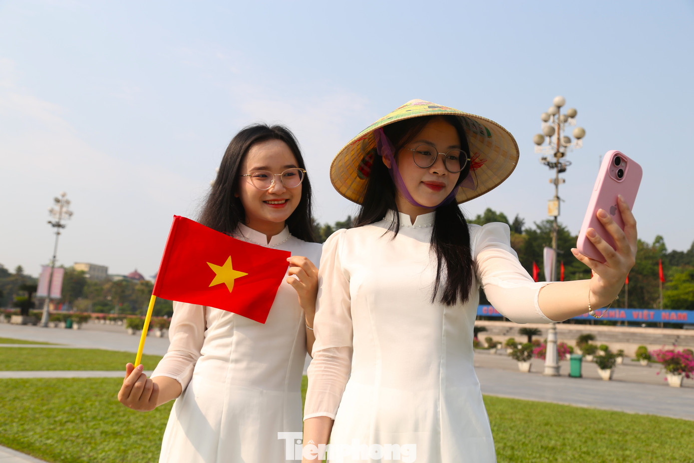 Đôi bạn “song Thương”, Hứa Thị Hoài Thương và Nguyễn Thị Thương (sinh viên trường Đại học Vinh) rạng rỡ trong trang phục áo dài trắng cùng lá cờ Tổ quốc và chiếc nón lá.