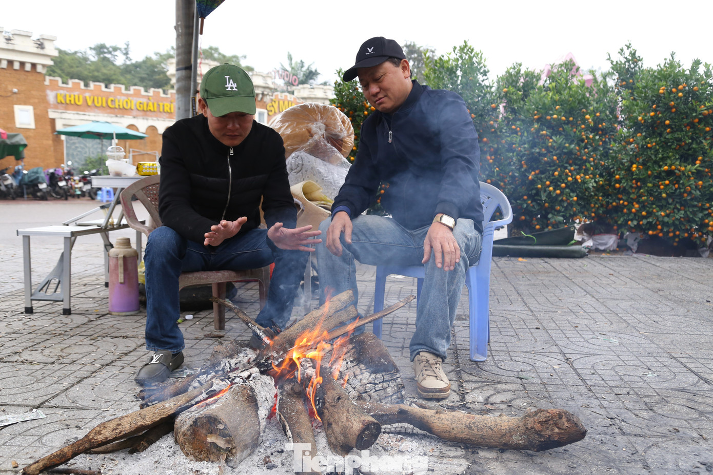Cách đó không xa, nhóm của anh Hoàng Văn Minh đang nhóm củi sưởi ấm, chờ khách đến xem cây. Năm nay, anh Minh nhập về khoảng 300 gốc quất, bưởi Tết, tuy nhiên sức mua giảm mạnh. “Chợ vắng, người bán đông hơn người mua. Anh em ai cũng sốt ruột cả. Lỡ bỏ hàng trăm triệu tiền vốn trong vụ Tết này rồi, trời rét cũng phải bám trụ thôi chứ không có cách nào khác”, anh Minh than thở.
