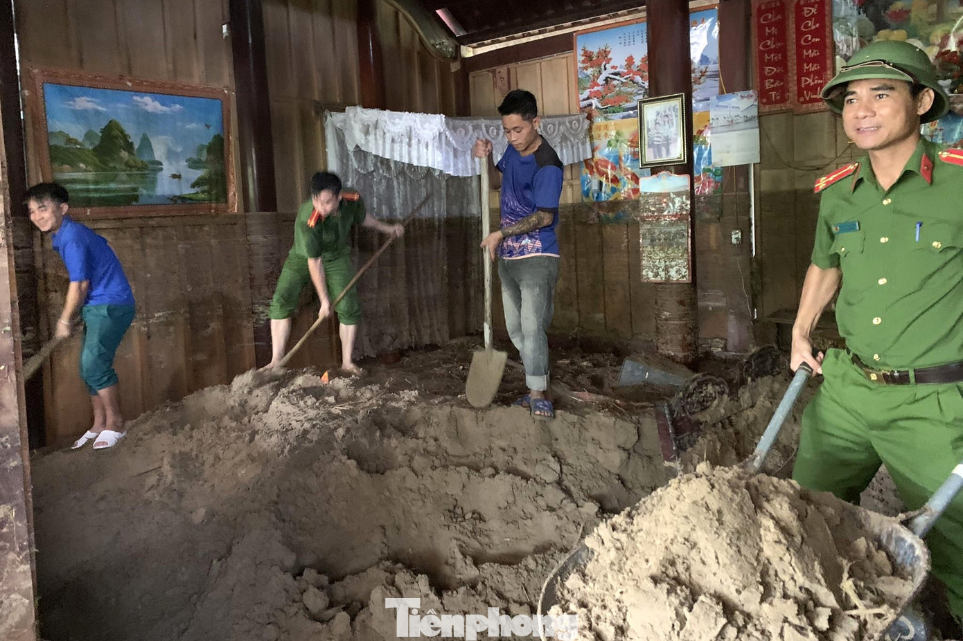 Lượng lớn đất tràn vào nhà, lực lượng công an, đoàn viên thanh niên hỗ trợ xúc đất ra ngoài.