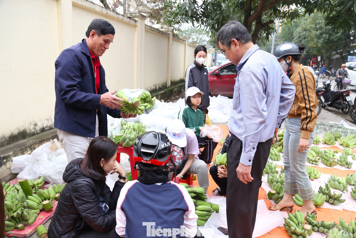 Theo các tiểu thương, giá mỗi nải chuối còn phụ thuộc vào màu sắc, quả to/nhỏ, số quả chẵn/lẻ, còn nguyên râu hay không, có bị “dị tật” hay không. Trong ảnh, rất đông người dân chen chân mua chuối xanh ngày Tết.