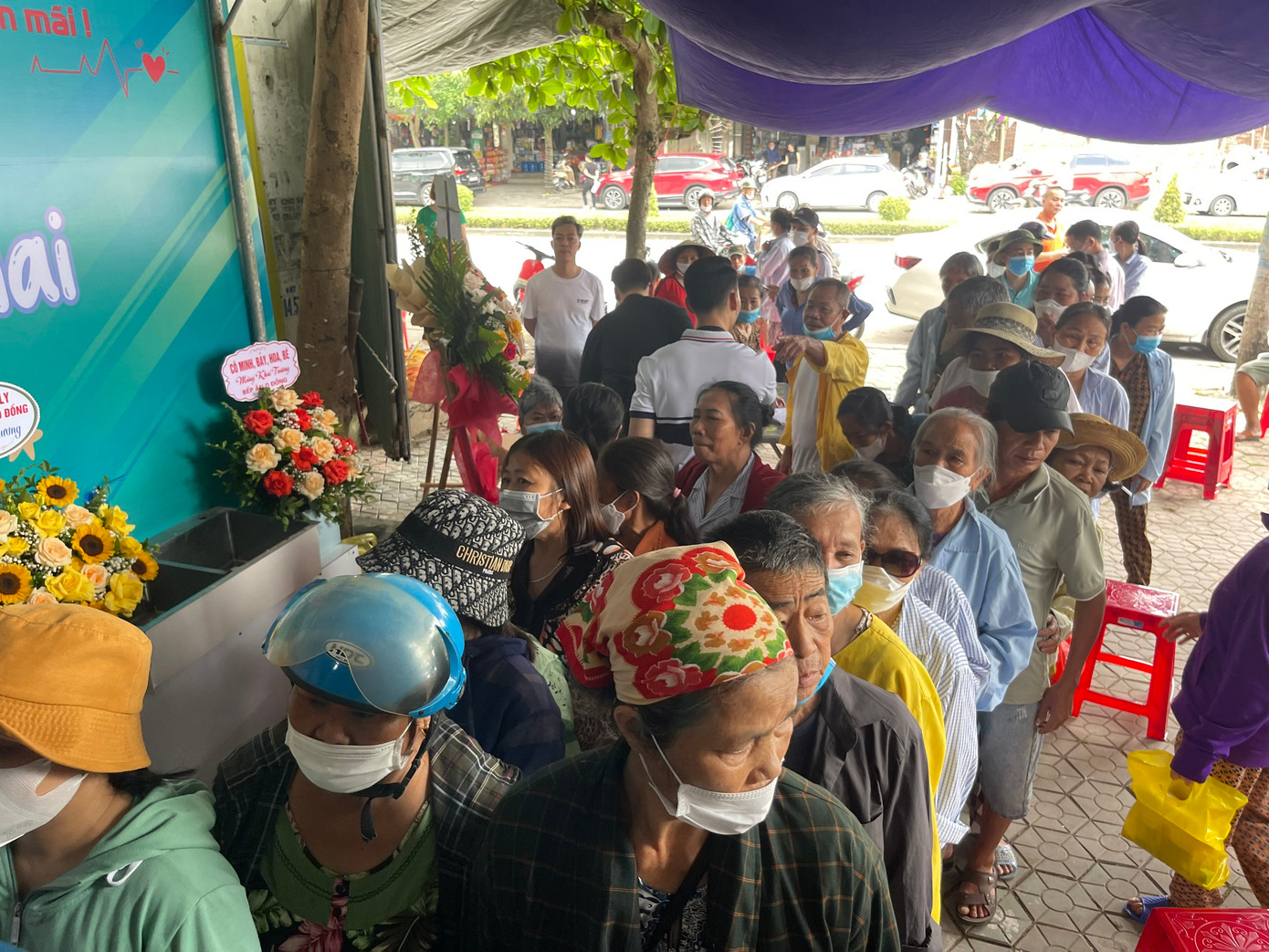 Bệnh nhân và người nhà xếp hàng nhận suất cơm của mình đã đăng ký. Ảnh: Phương Nhung