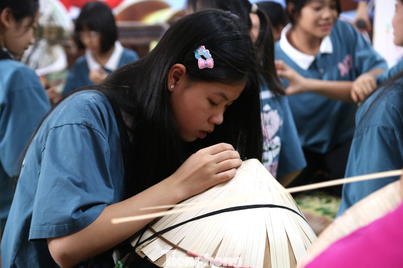 Các em say sưa chằm nón.