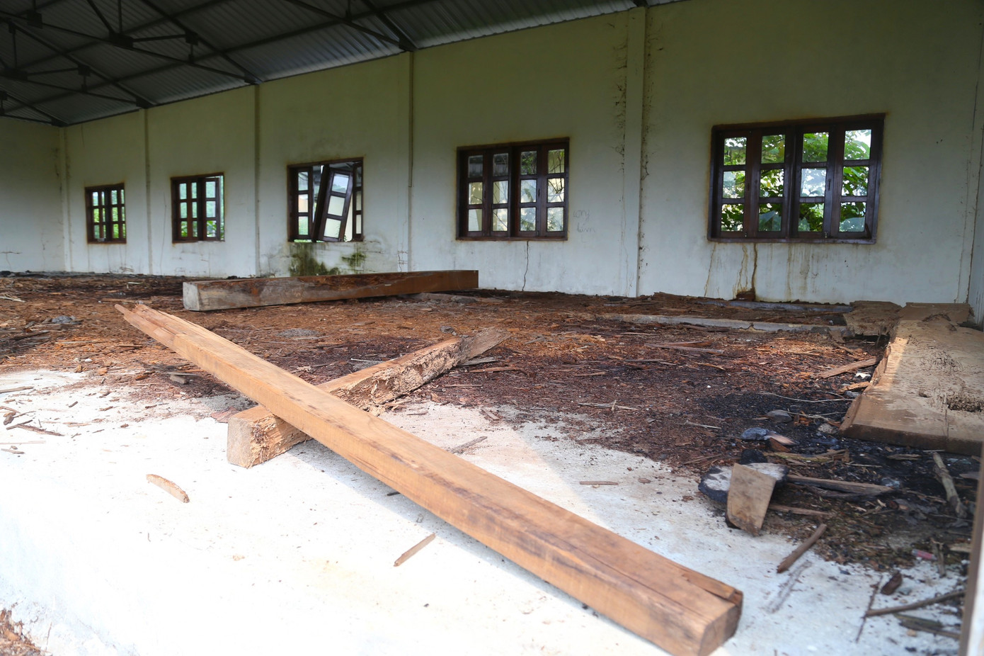 Bên trong một dãy nhà, mùn cưa, gỗ tạp ngổn ngang.