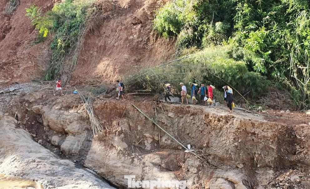 Giáo viên băng qua đoạn đường sạt lở, hư hỏng nghiêm trọng (Ảnh: LH)