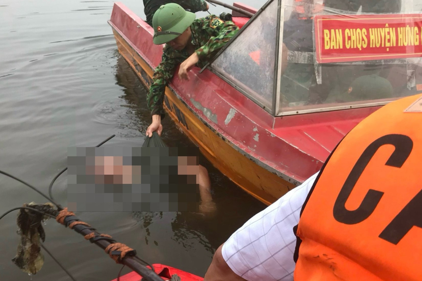 Lực lượng chức năng trục vớt thi thể anh H. Lực lượng chức năng trục vớt thi thể anh H.