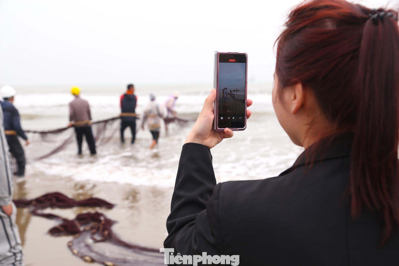 Du khách thích thú quay video ngư dân kéo lưới rùng.