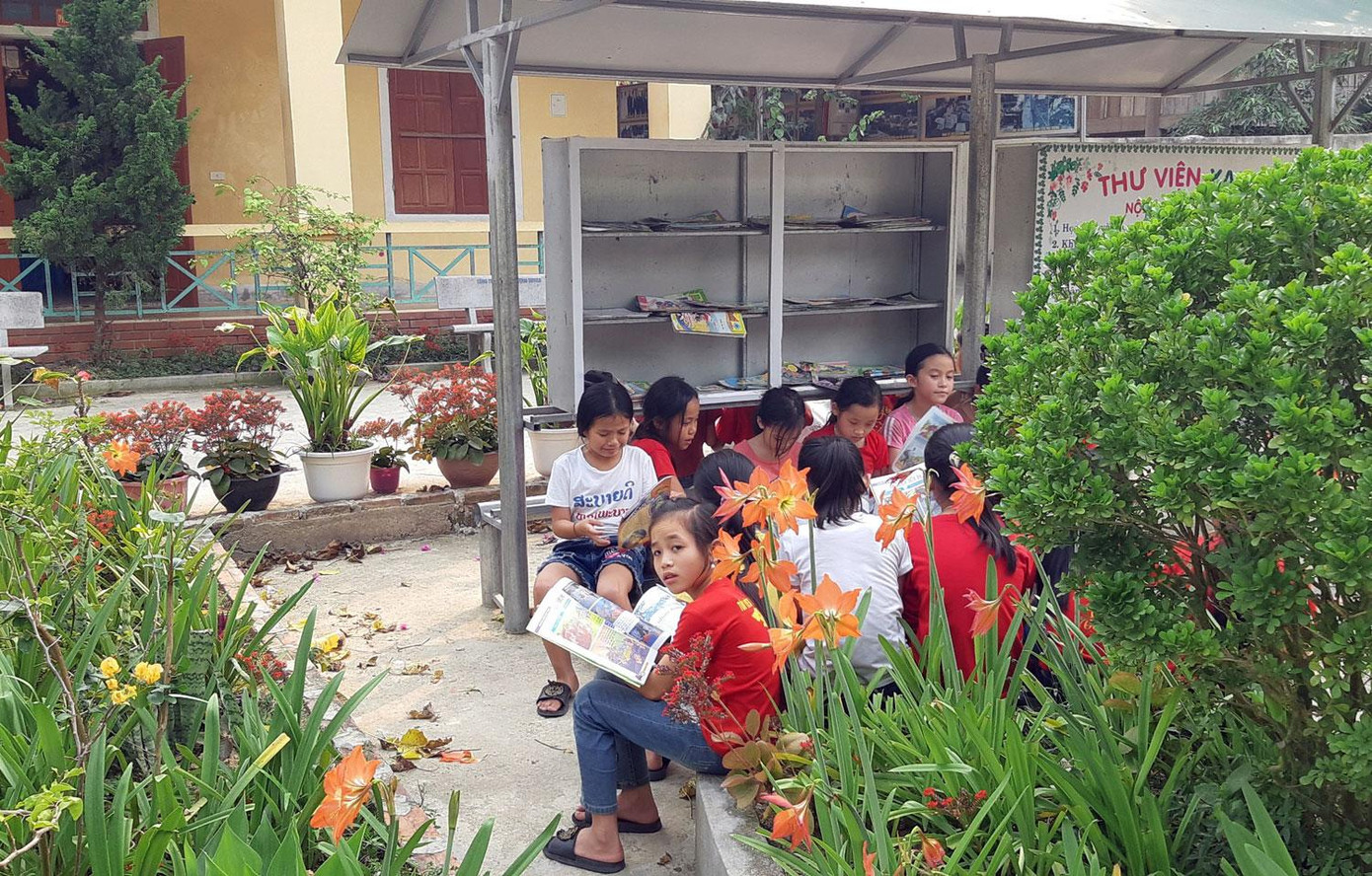 "Thư viện mini" được dựng lên xung quanh những bồn hoa giúp học sinh hòa vào thiên nhiên, biết yêu thiên nhiên hơn.